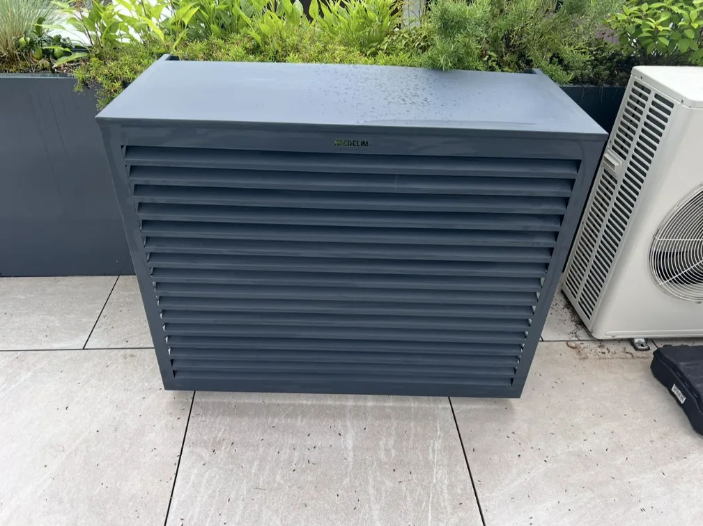 Klima-Außengerät mit Lamellen-Schutzverkleidung auf einer Terrasse